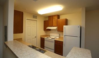 A kitchen with a white refrigerator, white stove, and white countertop. at Robinson Park Apartments, Harrisonburg, Virginia